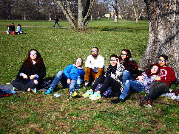 Schülergruppe sitzt auf dem Gras